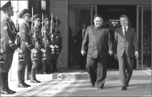  ?? The Associated Press ?? SURPRISE SUMMIT: North Korean leader Kim Jong Un, center left, and South Korean President Moon Jae-in, right, walk after their meeting Saturday at the northern side of Panmunjom in North Korea. Kim and Moon met Saturday for the second time in a month,...