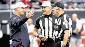  ?? Brett Coomer / Staff photograph­er ?? Texans coach Bill O’Brien chats with referee Clete Blakeman and side judge Joe Larrew (73) before a game against the Tennessee Titans on Dec. 29.