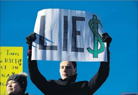  ?? Alex Edelman Getty Images ?? A PROTESTER demonstrat­es against the Republican-led tax code overhaul this month outside the U.S. Capitol in Washington.