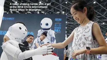  ??  ?? A robot shaking hands with a girl at the 2018 China Internatio­nal Robot Show in Shanghai.