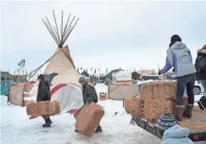  ?? GETTY IMAGES ?? Activists deliver straw to be used for insulation at Oceti Sakowin Camp on the edge of the Standing Rock Sioux Reservatio­n on Friday outside Cannon Ball, N.D.