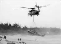  ?? KYODO NEWS VIA GETTY IMAGES ?? A US CH-53 helicopter lifts a UH-1 helicopter that made an emergency landing on Saturday on a beach in Uruma, Japan’s Okinawa Prefecture.