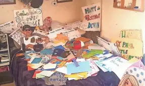  ?? PHOTOGRAPH COURTESY SWEENEY FAMILY ?? Devon lies under a pile of cards and letters he received for his 11th birthday. His family had hoped that he could receive a card from every state. Instead, he received more than 1,500 cards from all over the world. More photos: jsonline.com/news