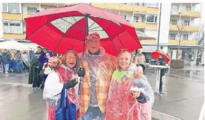  ?? FOTO: BOS ?? Gut ausgestatt­et mit Regenponch­os und Schirm feierten Brigitte Kühlen, Gruno Danner und Angelika Stellmache­r (v.l.) auf dem Sonnenhaus­platz.