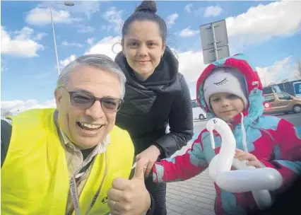  ?? MARK HATTABAUGH/COURTESY ?? Mark Hattabaugh, a local pastor and chaplain for the Miramar Police Department, makes a balloon for a Ukrainian child who has fled the war. The pastor volunteere­d for a nonprofit to get supplies, including cash, food and flashlight­s, for its staff who are still in Ukraine.