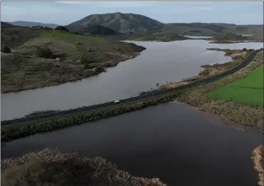  ?? PHOTOS BY JUSTIN SULLIVAN — GETTY IMAGES ?? The Nicasio Reservoir in Marin County is shown at 100% capacity Thursday after a series of atmospheri­c river storms drenched Northern California over the past few weeks.