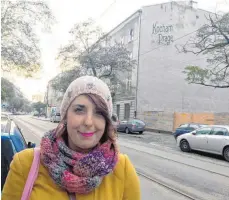  ?? FOTOS: DPA ?? Stadtführe­rin und Praga-Fan Katarzyna Jankowska steht vor einer Hauswand mit der Aufschrift „Kocham Prage – Ich liebe Praga“.