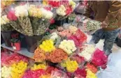  ?? AP PHOTO/CHARLES REX ARBOGAST ?? A shopper at a Chicago area grocery store looks over Valentine’s Day flowers Saturday.