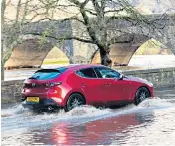  ?? ?? Heavy rain: a motorist drives through flood water at Builth Wells in Powys