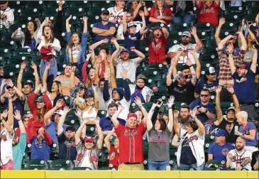  ?? CURTIS COMPTON/CURTIS.COMPTON@AJC.COM ?? Braves and Cubs fans get the wave going during Monday’s game at Truist Park. The Braves, who limited stadium capacity to 50% during their current homestand, will increase capacity to 100% — about 41,000 seats — beginning with the May 7 game against the Philadelph­ia Phillies.