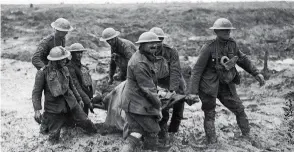  ??  ?? SACRIFICE Soldiers carry a wounded comrade through the mud near Boesinghe during the Battle of Passchenda­ele in Flanders, Belgium