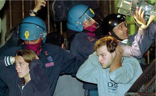  ??  ?? Il gesto Alcuni dei manifestan­ti contro il G8 di Genova la sera del 22 luglio 2001 dopo il blitz delle forze dell’ordine all’interno della scuola Diaz
(foto di Luca Bruno/Ap)