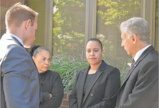  ?? BRETT SHOLTIS/ WITF ?? Rulennis Munoz ( center right) outside the Lancaster, Pennsylvan­ia, courthouse after learning that the police officer who fatally shot her brother had been cleared of criminal wrongdoing by the Lancaster County district attorney. Her mother, Miguelina Peña, and her lawyer Michael Perna ( far right) stood by.