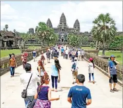  ?? HONG MENEA ?? Tourists approach Angkor Wat in Siem Reap province. Internatio­nal visitors to the Kingdom dropped 78 per cent last year.