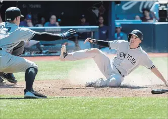  ?? FRED THORNHILL THE CANADIAN PRESS ?? New York Yankees’ Tyler Wade scores the winning run as Aaron Judge reacts in the 10th inning Sunday.