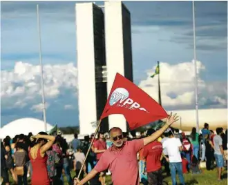  ?? Walterson Rosa - 28.abr.17/Fotoarena/Folhapress ?? Manifestan­te com bandeira de sindicato protesta no DF na sexta (28), dia da greve geral