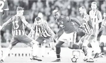  ?? — AFP photo ?? Manchester United’s midfielder Paul Pogba (centre) vies with Brighton’s German midfielder Pascal Gross (left), Brighton’s Dutch midfielder Davy Propper and Brighton’s English striker Glenn Murray during the English Premier League match at the American...