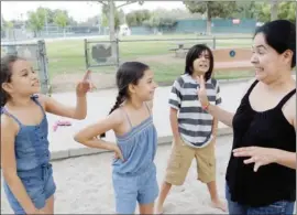  ??  ?? Karen Mejia, with her twin girls Anais, left, and Keila, 11, and son Andres, 13. Mejia embraces “nonviolent parenting,” avoiding rewards, bribes or punishment­s.