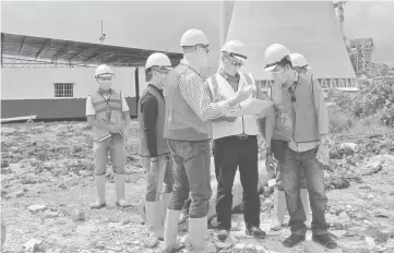  ??  ?? Lawrence (left) checks on the work progress at the coal stockyard project site.