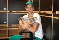  ?? FIONA HAMILTON / TENNIS AUSTRALIA VIA AP ?? Novak Djokovic embraces the Norman Brooks Challenge Cup in the locker room after defeating Daniil Medvedev in the men’s singles final at the Australian Open in Melbourne, Australia.