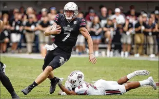  ?? ROGELIO V. SOLIS / AP ?? Mississipp­i State quarterbac­k Nick Fitzgerald (left), running past a UMass defender, has rushed for more than 100 yards in four consecutiv­e games, all victories for the No. 16 Bulldogs.