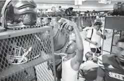  ?? Los Angeles Times/TNS ?? Mesquite High wide receiver Ja’Darion Smith, 15, reaches to put away his uniform on the top shelf of his locker Aug. 30 following football practice in Mesquite, Texas. One of Jordan Edwards’ best friends, Ja’Darion now prays before bed and as he walks...