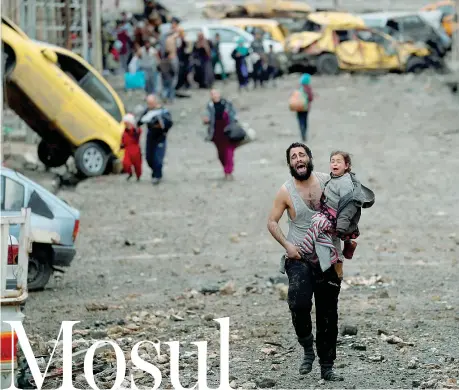  ??  ?? In fuga Un uomo corre con in braccio la figlia da una zona di Mosul in mano all’Isis (Reuters/ Goran Tomasevic)