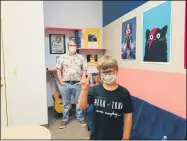  ?? SUBMITTED BY JACLYN BRADLEY ?? Guitar student Jakob Kozlowski, 8, gestures for a photo while guitar teacher Wesley Crow looks on at the Lorain Rock Town Music Academy, 401 Broadway Ave. in Lorain.
