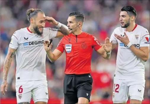  ?? ?? Nemanja Gudelj y Rafa Mir protestan a Del Cerro Grande una de las dos expulsione­s, vía VAR, del árbitro madrileño.