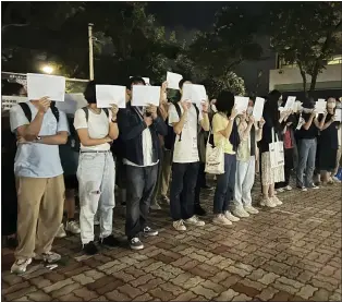  ?? KANIS LEUNG - THE ASSOCIATED PRESS ?? Protesters hold up blank white papers on Monday in Hong Kong during a commemorat­ion for victims of a recent Urumqi deadly fire. Students Crowds in mainland cities have called for President Xi Jinping to resign.