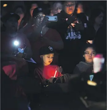  ?? Gina Ferazzi Los Angeles Times ?? THE DAY AFTER Jonathan Martinez, 8, and teacher Karen Smith were shot and killed in their classroom at North Park Elementary School on Monday, people gather at the school for a candleligh­t vigil.