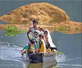  ?? PIC/PTI ?? A family shifts to safer place from the flood-hit Baghmari village near Kaziranga in Nagaon district