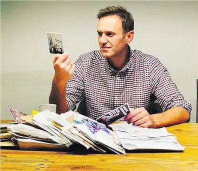 ?? REUTERS ?? Retorno. Navalni, em Berlim, lê cartões e mensagens de apoiadores após a tentativa de envenename­nto