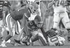  ?? COLUMBUS DISPATCH FILE PHOTO ?? Ohio State quarterbac­k Troy Smith is sacked by Florida’s Earl Everett, middle, and Derrick Harvey during the national championsh­ip game on Jan. 8, 2007.