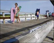  ?? MEL EVANS / AP ?? People stream onto the beach Tuesday at Island Beach State Park in Seaside Park, N.J., after a budget impasse between the Republican governor and Democratic lawmakers shut down the government.