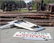  ?? Photos by Doug Walker, Rome News-Tribune ?? ABOVE: Logs knocked down the sign for La Cabana restaurant after a log truck flipped at the intersecti­on of Ga. 100 and U.S. 411 in Cave Spring. The driver was taken to Floyd Medical Center with undisclose­d injuries.