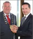  ??  ?? Cllr. Keith Doyle receives the chain of office from outgoing chairman Cllr. John Hegarty.