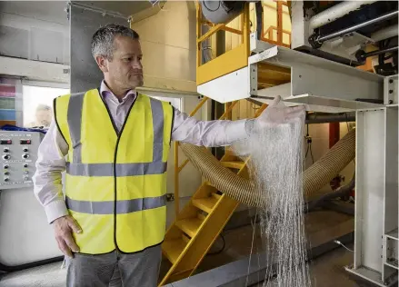  ?? PHOTO: REUTERS ?? A changing industry . . . Gareth KaminskiCo­ok, chief executive of Autins, which makes noisereduc­ing and thermal insulation for carmakers, catches insulation fibres as they come out of a machine that is ramping up for production at the auto supplier’s factory in Tamworth, Britain.