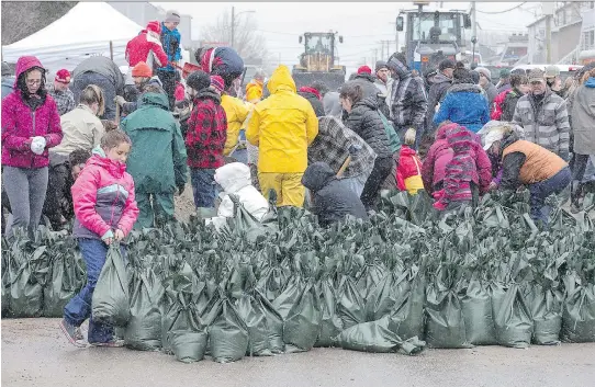  ?? WAYNE CUDDINGTON ?? Volunteers are pitching in with sandbaggin­g at Rue Saint-Louis and Rue Moreau in Gatineau as flooding continues throughout the region in areas along local rivers.