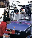  ?? ?? A woman plays ping pong with a ping pong robot developed by Omron at the fourth China Internatio­nal Import Expo, Nov. 6, 2021. (People’s Daily Online/xu Congjun)