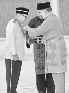  ??  ?? Sultan Muhammad V bestows the Darjah Panglima Jasa Negara (P.J.N) on Ahmad Lai Bujang. — Bernama photo