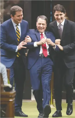 ?? Adrian Wyld / the Cana dian pres ?? Prime Minister Justin Trudeau and then Leader of the Opposition Andrew Scheer drag Liberal MP Anthony Rota to the Speaker’s chair after he was elected Speaker of the House on Dec. 5, 2019.