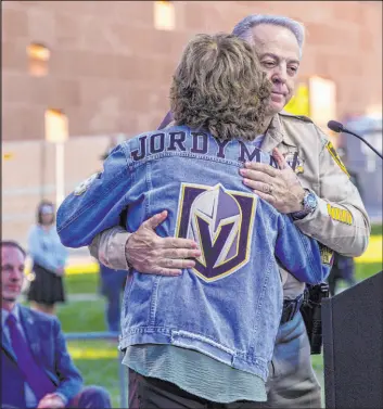  ?? L.E. Baskow Las Vegas Review-journal @Left_eye_images ?? Angela Mcildoon hugs Sheriff Joe Lombardo after talking about her son, Jordan. “I still look for him, and I sometimes see him in the scruffy red beard of a young man in line, or a well-worn pair of boots and jeans on someone,” she said.