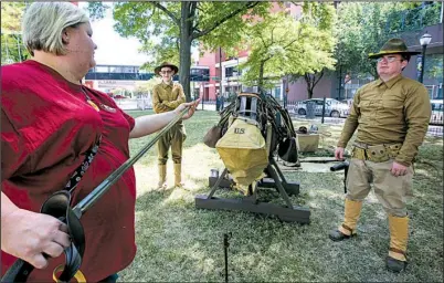  ?? Arkansas Democrat-Gazette/MITCHELL PE MASILUN ?? Amber Bingham of Clinton, Ala., (from left) checks out a saber as re-enactors Blake Phillips of Donaldson and Randall Watts of Black Rock take part in an event Saturday at the Old State House Museum in Little Rock to commemorat­e the 100th anniversar­y of the U.S.’ entry into World War I.