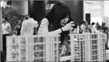  ?? PROVIDED TO CHINA DAILY ?? A Hangzhou denizen takes pictures of models of a housing estate at a sales center. China’s prominent property firms are entering the long-term home lease market, in line with government policy.