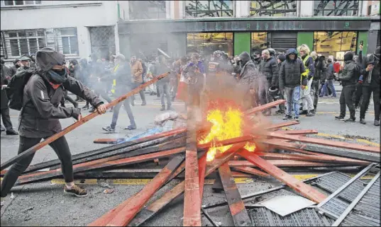  ?? Michel Euler The Associated Press ?? A demonstrat­or sets up a barricade and starts a fire during a protest Saturday in Paris against pension reform plans.