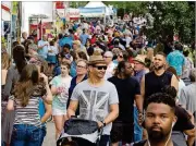  ??  ?? A large crowd walks past the food and artist booths during the 82nd Annual Atlanta Dogwood Festival in Piedmont Park.