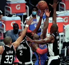  ?? ROBERT HANASHIRO/USA TODAY SPORTS ?? Thunder forward Luguentz Dort (5) puts up a shot between Clippers forward Nicolas Batum (33), forward Kawhi Leonard (2) and center Serge Ibaka (9) in the second quarter Friday at Staples Center.