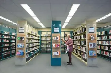  ?? BRIAN KRISTA/STAFF ?? A woman browses a section of books at the Catonsvill­e branch of the Baltimore County Public Library in May 2021. A bill before the Maryland legislatur­e would protect libraries from unconstitu­tional censorship.