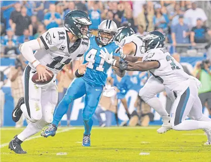  ??  ?? Eagles quarterbac­k Carson Wentz, left, looks to pass against the Panthers.